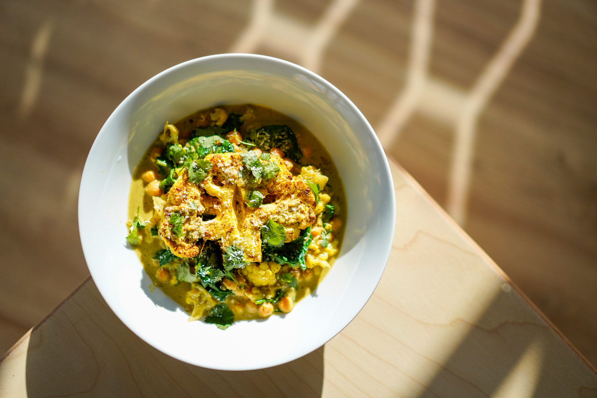 Bowl of brightly coloured cauliflower and chickpea curry.