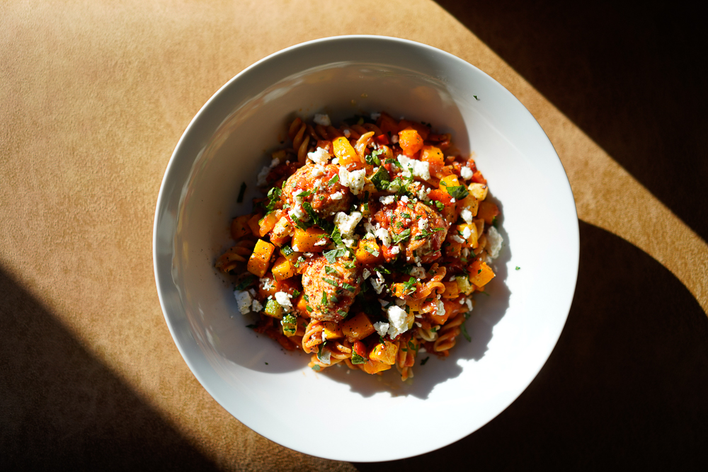 Turkey meatballs and feta cheese sit atop a fresh veggie pasta.