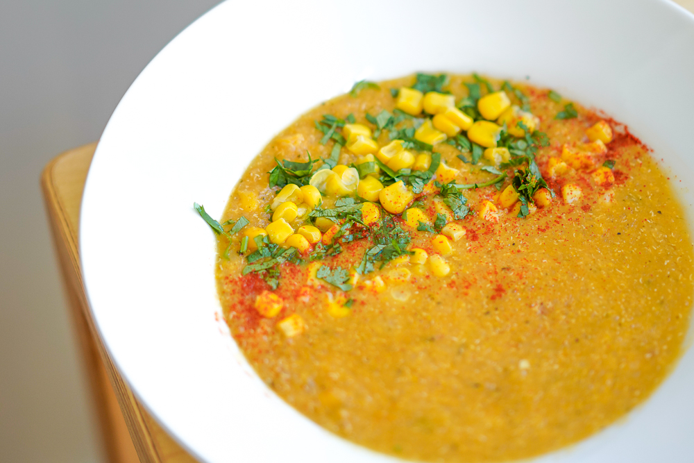 Sweetcorn, coriander and a little chilli sit on top of a yellow chowder